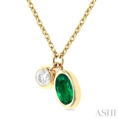 1/50 ctw Oval Cut 5X3MM Emerald and Bezel Set Round Cut Diamond Precious Necklace in 10K Yellow Gold